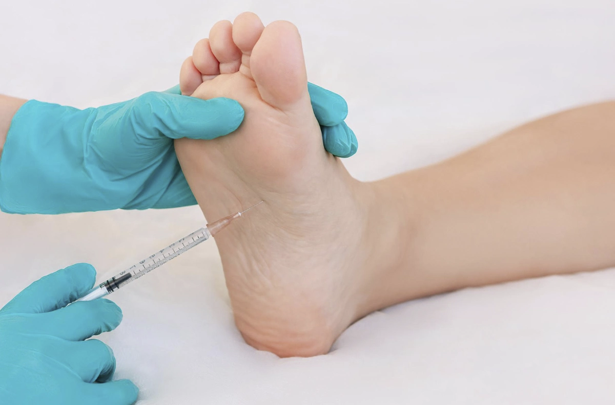 manos pinchando en la planta del pie