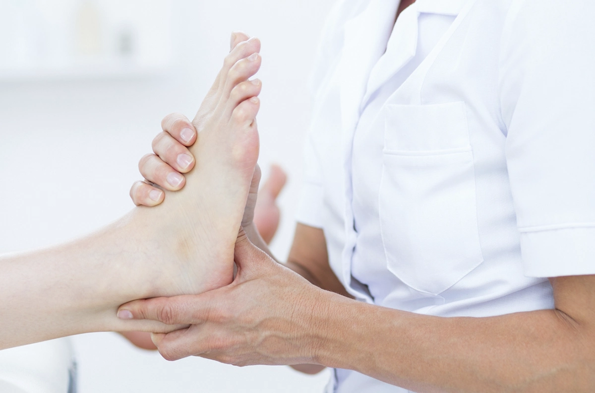 manos tocando talón del pie